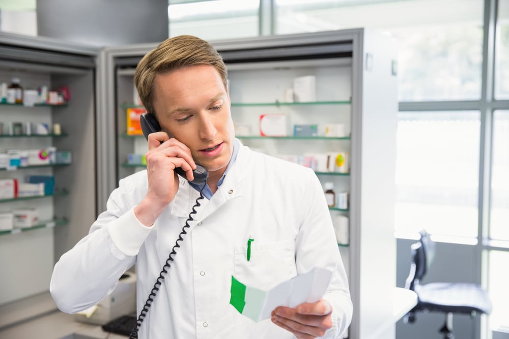 Happy pharmacist on the phone at the hospital pharmacy